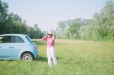 Une dame se tient devant une voiture Citiz lors d'une promenade au vert.